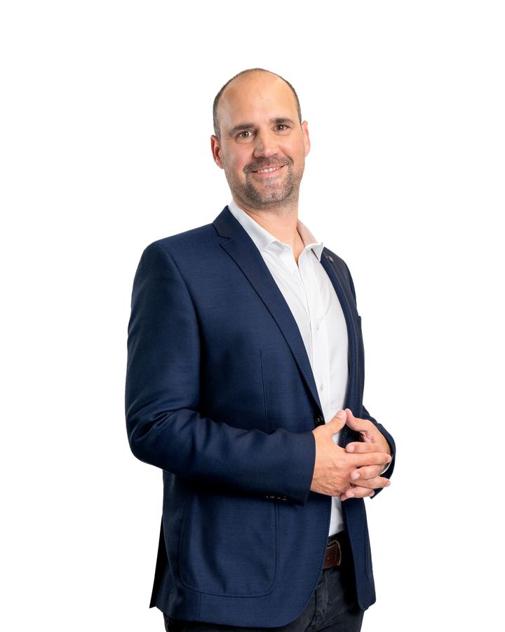 Ralf Aigner im Studio, die Hände locker gefaltet